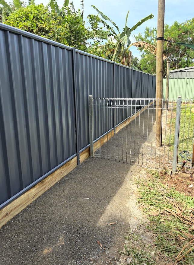 Grey Colorbond fence with galvanised steel pool gate along a side access path in Cairns